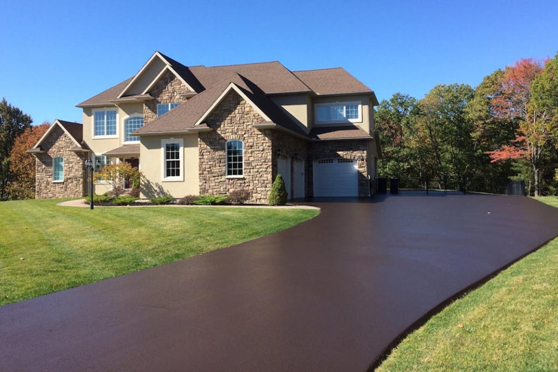 Fresh asphalt driveway in front of a home.